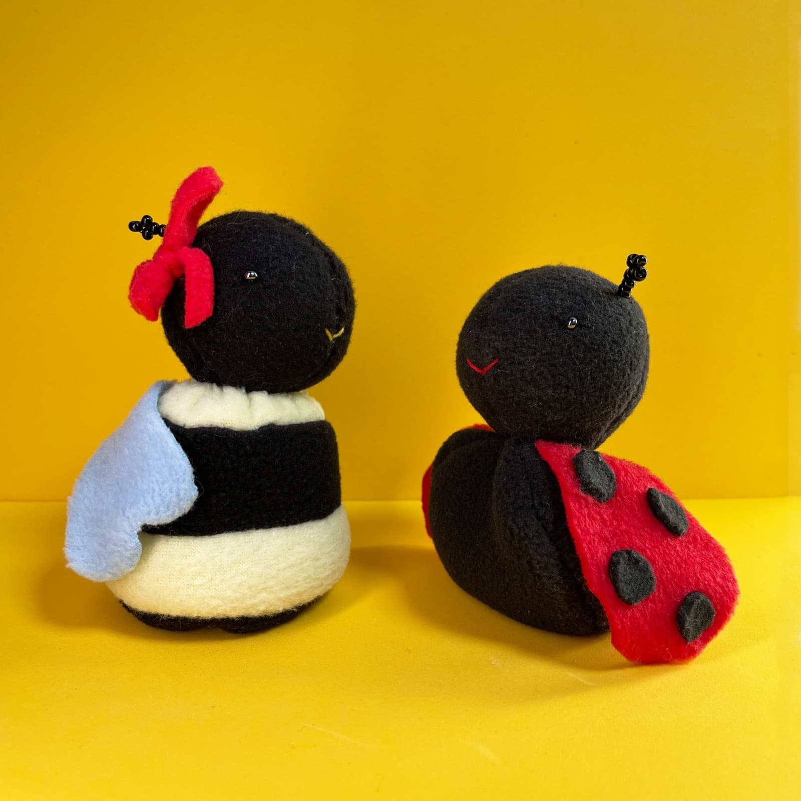 Two handmade Avery characters against a bright yellow background