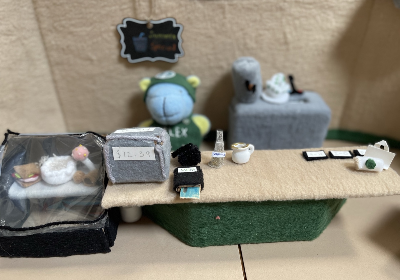 A handmade miniature café counter filled with tiny details