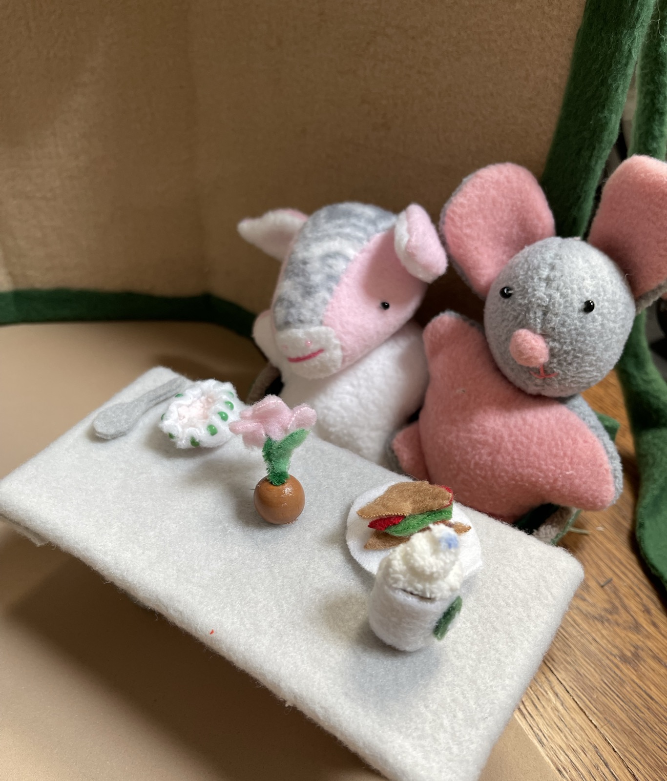 Handmade animal friends sharing treats at a miniature table