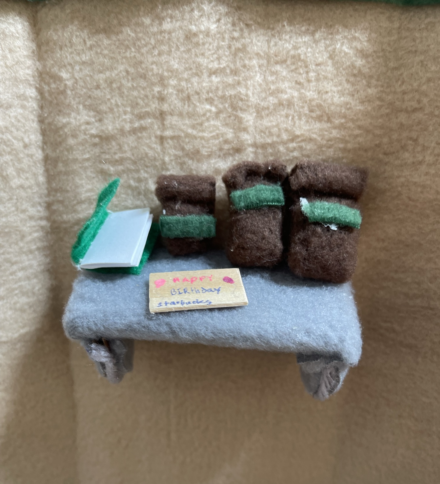 A handmade miniature shelf with tiny cups and books
